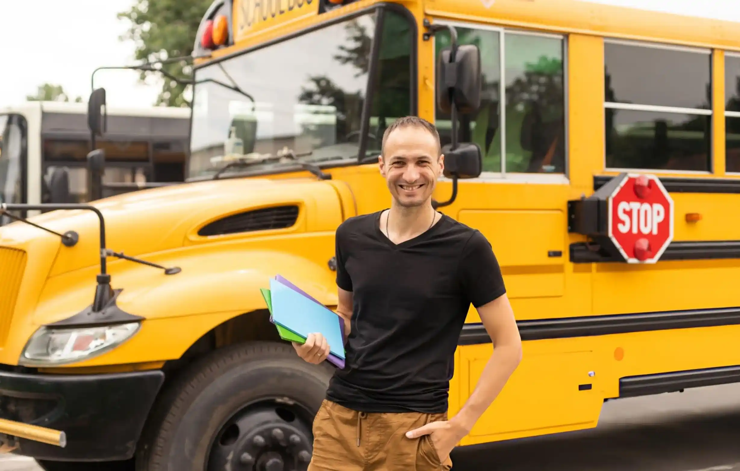 AJ Bus Lines team member standing near a school bus